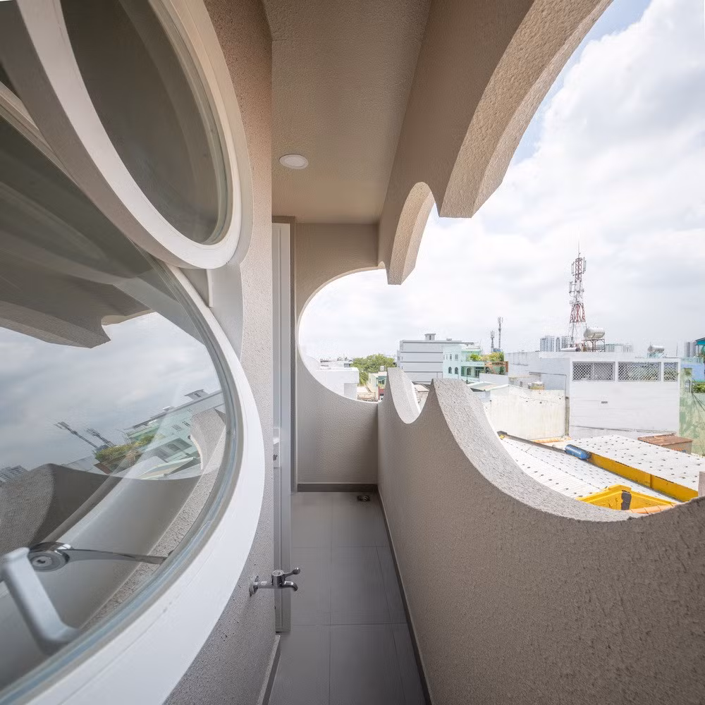 Điểm đặc biệt của ngôi nhà nằm ở các ô cửa hình tròn và hình đám mây mềm mại, vừa lấy sáng, thông gió, vừa tạo nên hiệu ứng thị giác đẹp mắt. Ảnh: Sonmeo Nguyen Art Studio