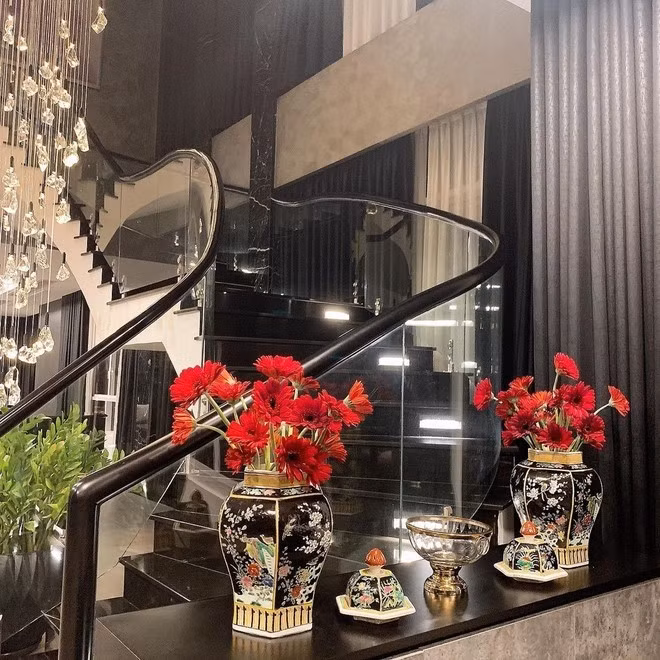 Tầng 1 và tầng 2 liên kết bởi cầu thang bằng gỗ và kính, cây và hoa tươi được đặt khắp lối đi. Ảnh: FBNV