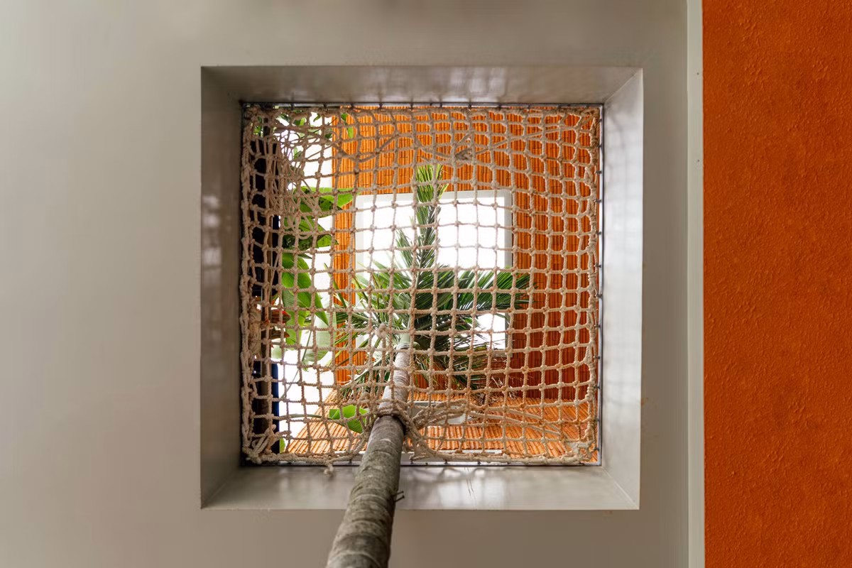 Dưới cây cau, một tấm lưới lớn được bố trí để trẻ em có thể leo trèo, đọc sách, hay đơn giản là nằm thư giãn. Ảnh: Phan Trọng Tín - Minh Anh