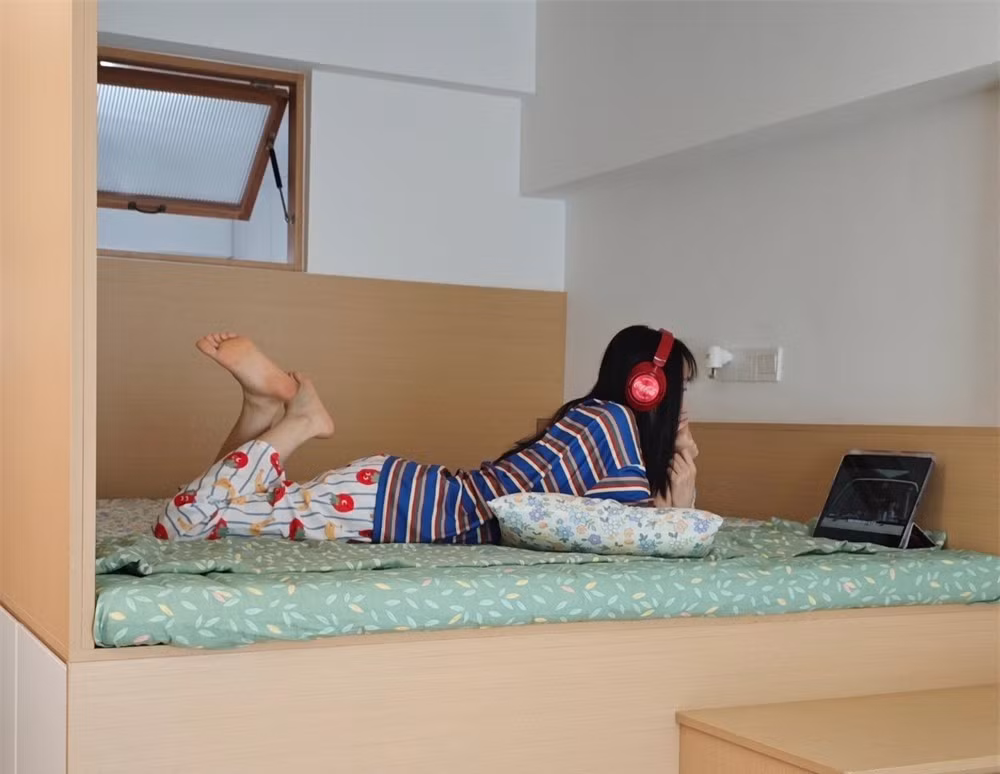 Đầu giường là tấm vách trắng đơn giản, phía trên có cửa sổ nhỏ đón ánh sáng từ bếp để căn phòng không bị tối hay bí bách. Ảnh: Sohu