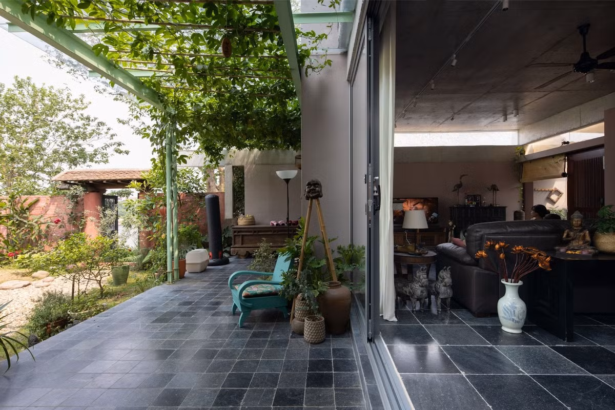 Ngôi nhà được thiết kế hướng nội. Các không gian sinh hoạt chung và phòng ngủ được đặt nhìn về phía sau nhà, nơi có một hàng hiên, một khu vườn trải dài xuống bờ sông. Ảnh: Chimnon studio