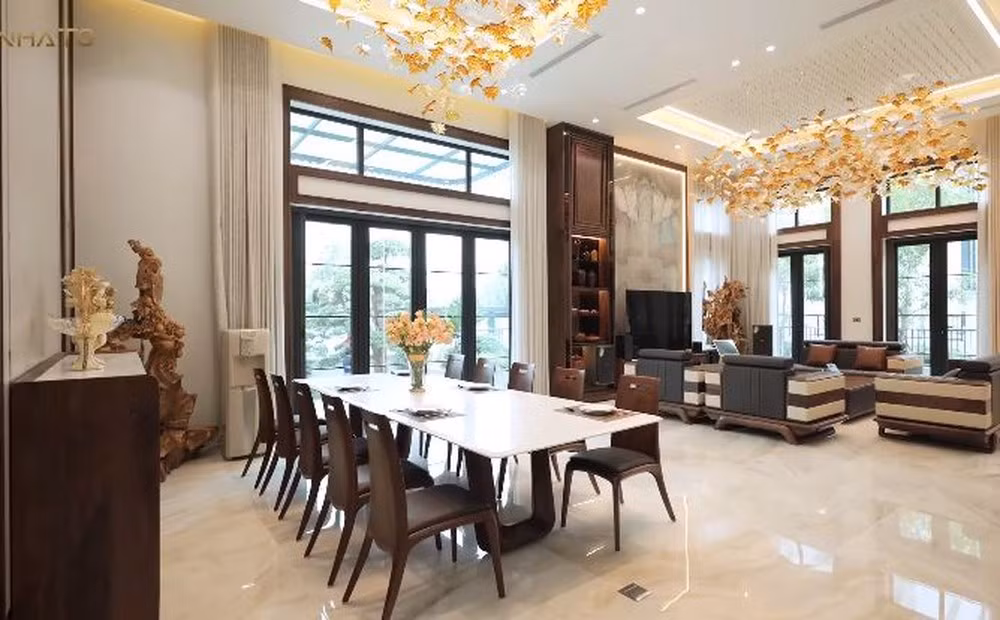 Tầng 1 là không gian phòng khách và bếp rộng thoáng, được bố trí nhiều đồ gỗ óc chó Mỹ. Ảnh chụp màn hình