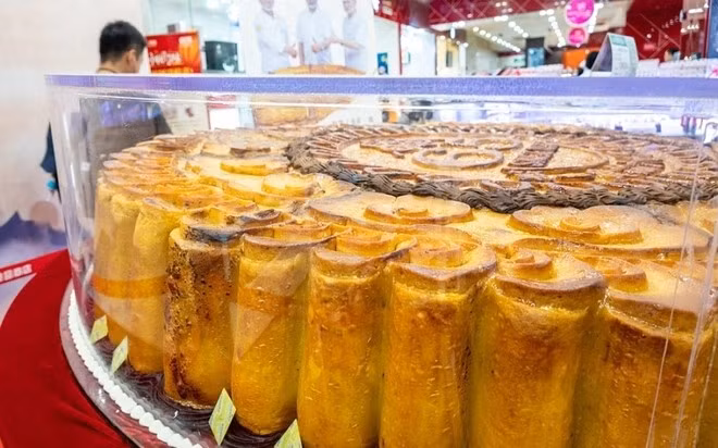 Để làm ra chiếc bánh, những người thợ phải sử dụng hơn 60 quả trứng, 60kg nhân hạt sen và 105 cốc bột mì. Ảnh: News