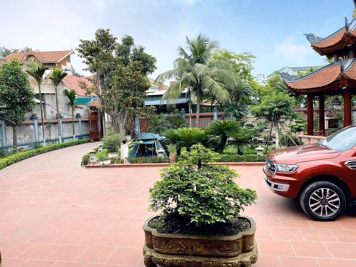 Bên ngoài là khoảng sân rộng, gồm một chòi lục giác chồng diêm đặt ngay cạnh hồ cá Koi. Ảnh: Happynest