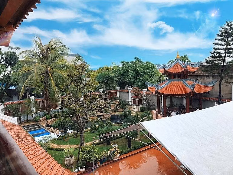 Công trình được xây trên khu đất rộng 900m2, bao gồm một căn nhà gỗ 5 gian, một gian nhà sinh hoạt chung rộng, cùng khoảng sân vườn và hồ cá bao quanh. Ảnh: Người quan sát
