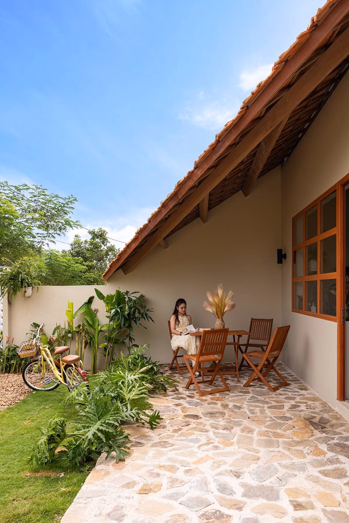 Mái hiên trước nhà rộng, đủ chỗ cho một bộ bàn ghế ngồi thưởng trà đọc sách. Ảnh: Bùi Minh Quốc