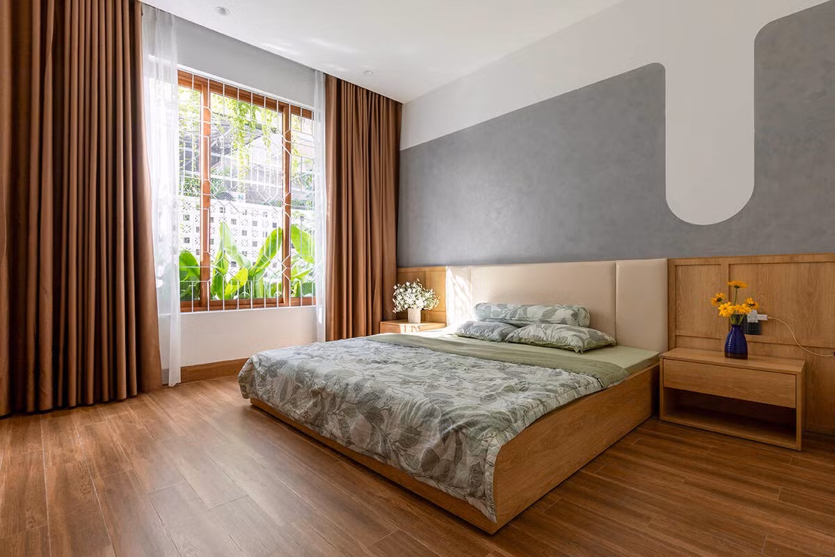 Phòng ngủ chính đặt ở tầng trệt với cửa kính lớn mở ra khu vườn phía sau. Ảnh: Khánh Nguyễn