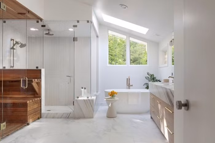 Phòng tắm sang trọng với buồng tắm kính, bồn tắm cạnh cửa sổ lớn. Ảnh: Homedit