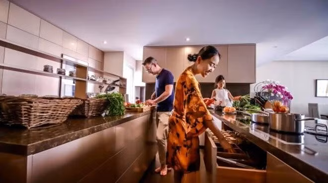 Căn hộ lưu giữ nhiều vật dụng thân quen chuyển từ Việt Nam sang. Phòng khách và bếp đặt chung trong không gian mở. Ảnh: FBNV