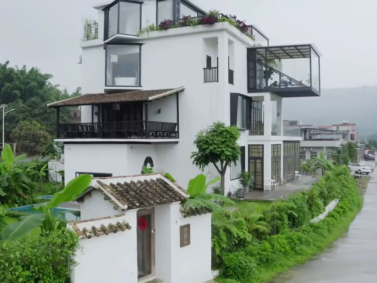 Căn biệt thự rộng khoảng 700m2 kết hợp giữa nét cổ điển Á Đông và hơi thở đương đại. Bên ngoài công trình phủ sơn trắng, khung cửa kính đen. Ảnh: BI