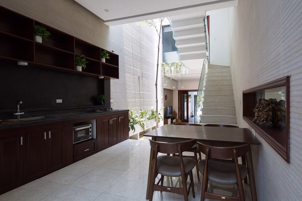 Khu vực bếp, bàn ăn sử dụng nội thất gỗ chủ đạo mang đến cảm giác trầm ấm. Ảnh: Hoàng Lê