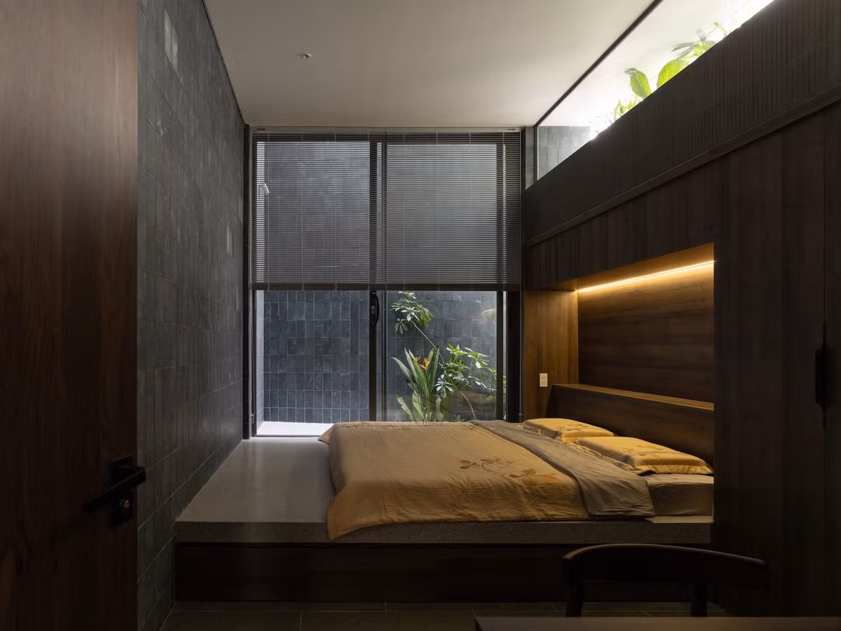Đi lên theo chiều dọc, cầu thang dẫn đến một sân trong rộng lớn ở trung tâm - một không gian sinh hoạt chung được mở rộng, đóng vai trò là "trái tim" của ngôi nhà. Các phòng ngủ riêng tư nằm ở hai đầu. Ảnh: Quang Dam