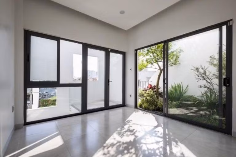 Tuy nhiên, với khí hậu nóng ẩm và mật độ nhà ở dày đặc tại đô thị, thiết kế này dễ gây nóng, chói và thiếu riêng tư. Ảnh: Hoàng Phi Glass