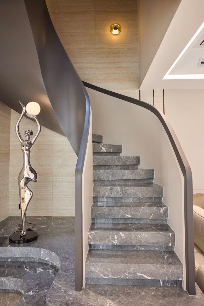 Bậc thang được ốp đá marble xám vân trắng, tay vịn uốn cong mềm mại. Ảnh: FBNV