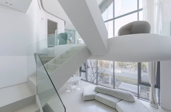 Cầu thang bố trí lệch tầng giúp ánh sáng len lỏi khắp không gian. Ảnh: Architizer