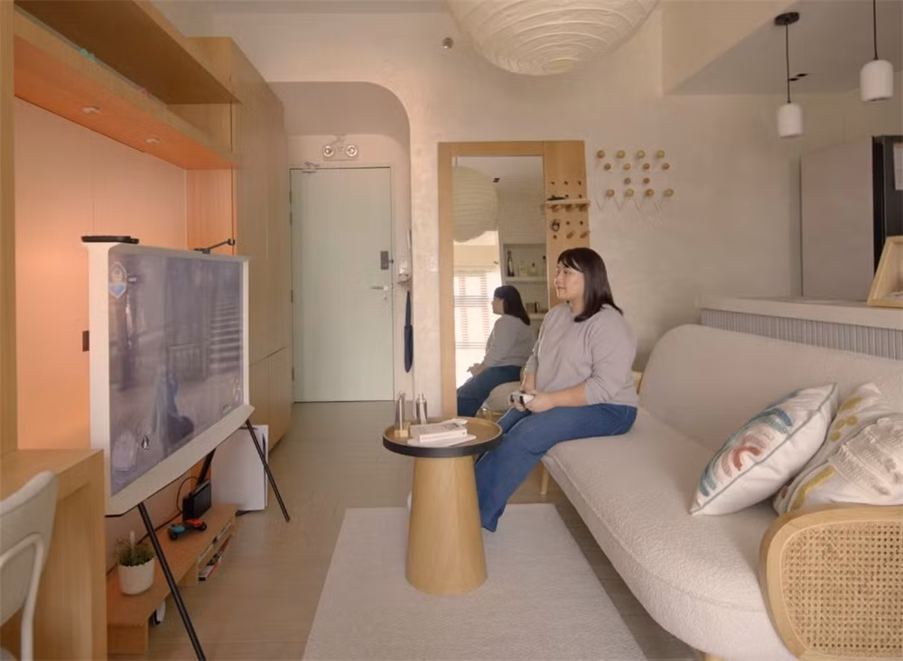 Từ cửa bước vào là không gian sinh hoạt chung gồm ghế sofa, bàn cà phê, tivi, bàn ăn dạng quầy bar và bếp mở nối tiếp nhau. Ảnh: Stackedhomes
