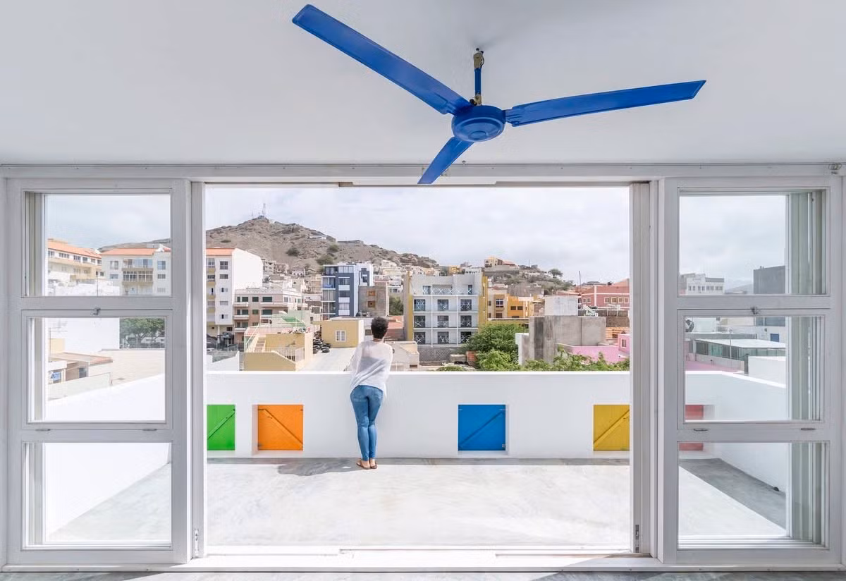Màu sắc của các cửa sổ có mối liên hệ trực tiếp với bảng màu đã có sẵn trong kiến ​​trúc truyền thống Cabo Verdian, và sự chuyển động của các ô cửa hấp thụ và truyền tải sự năng động và đối thoại với đường phố và trên hết là với hình khối không gian của các tòa nhà lân cận.