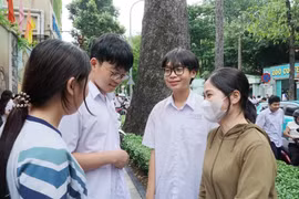 Thí sinh chia sẻ niềm vui với phụ huynh và bạn bè sau khi hoàn thành tốt bài thi. (Ảnh: Thu Hoài/TTXVN)