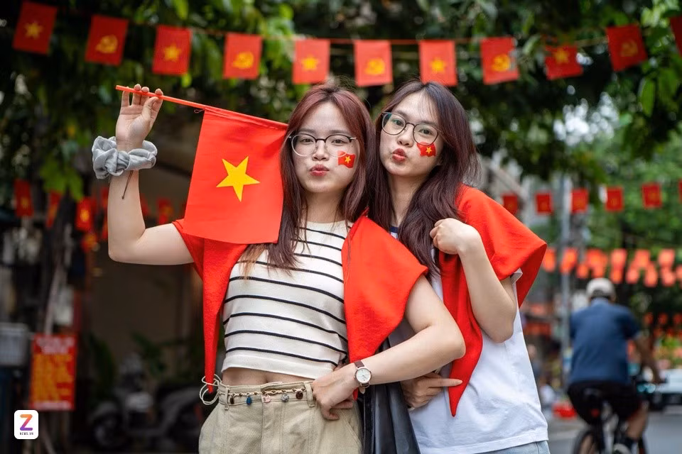 2 bạn trẻ với cờ đỏ sao vàng trên má và áo tại ngã tư Nguyễn Thái Học (Hà Nội) trong buổi tổng hợp luyện lần 1 A80, ngày 21/8/2025. Ảnh: Châu Sa.
