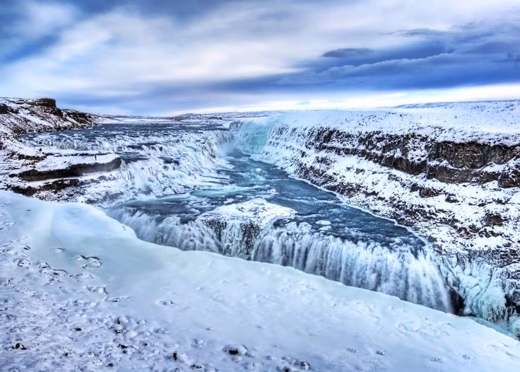  Cảnh sắc thay đổi theo mùa. Mùa hè, Gullfoss rực rỡ dưới ánh nắng. Đền mùa đông, thác đóng băng một phần, tạo nên khung cảnh huyền ảo như cổ tích. Ảnh: Pinterest.