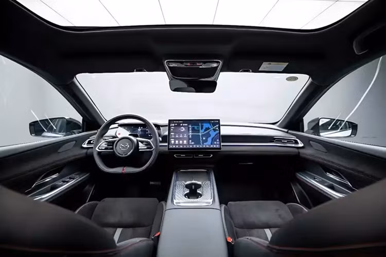Bên trong xe, Mazda EZ-6 Sports Edition được trang bị nội thất bọc bằng chất liệu Alcantara màu đen với các đường chỉ khâu màu đỏ-đen tương phản. Các chi tiết trang trí tối màu cũng xuất hiện ở cụm điều khiển trung tâm và cửa gió điều hòa. Thiết kế tổng thể tập trung vào sự khác biệt về mặt thị giác thay vì thay đổi cấu trúc.