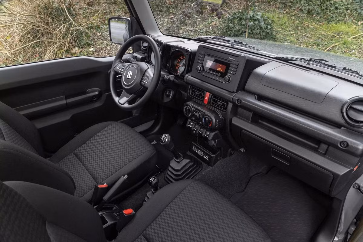Không gian bên trong Jimny bản đặc biệt vẫn giữ phong cách đơn giản vốn có của dòng xe off-road này. Xe được trang bị thảm sàn cao su cho cả khoang hành khách và khoang chứa đồ, lựa chọn phù hợp với nhu cầu đi đường xấu. Ở bảng điều khiển trung tâm, Suzuki gắn thêm một tấm biển kỷ niệm riêng để nhấn mạnh tính chất giới hạn của phiên bản.