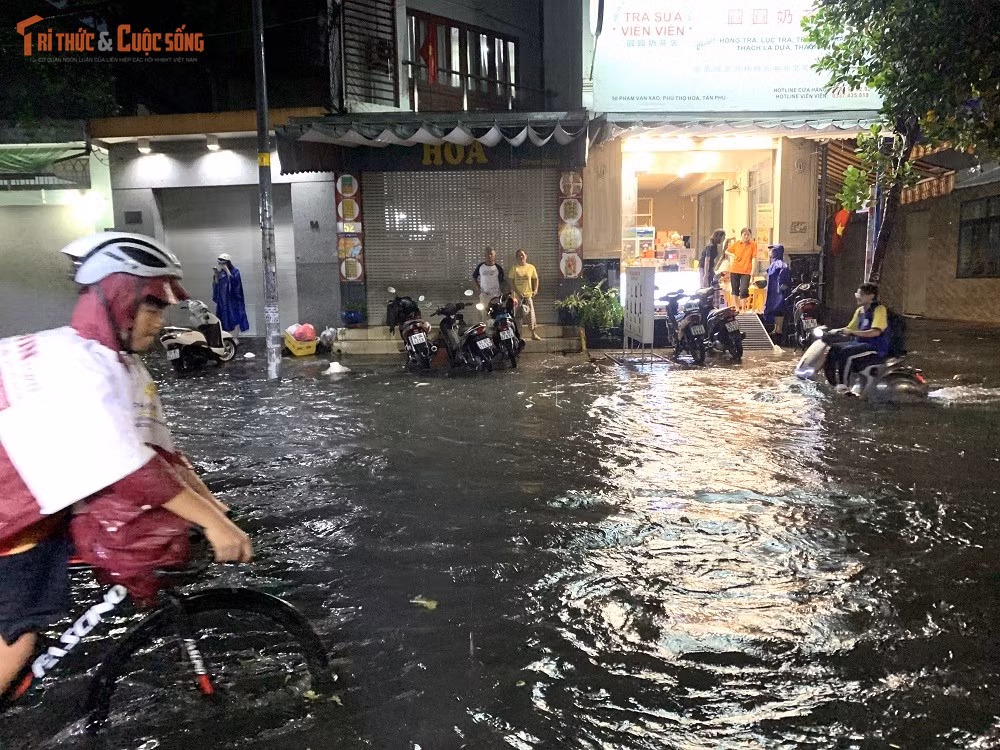 Nhiều người không dám đi vào vùng ngập sâu đành đứng hai bên đường chờ nước rút.