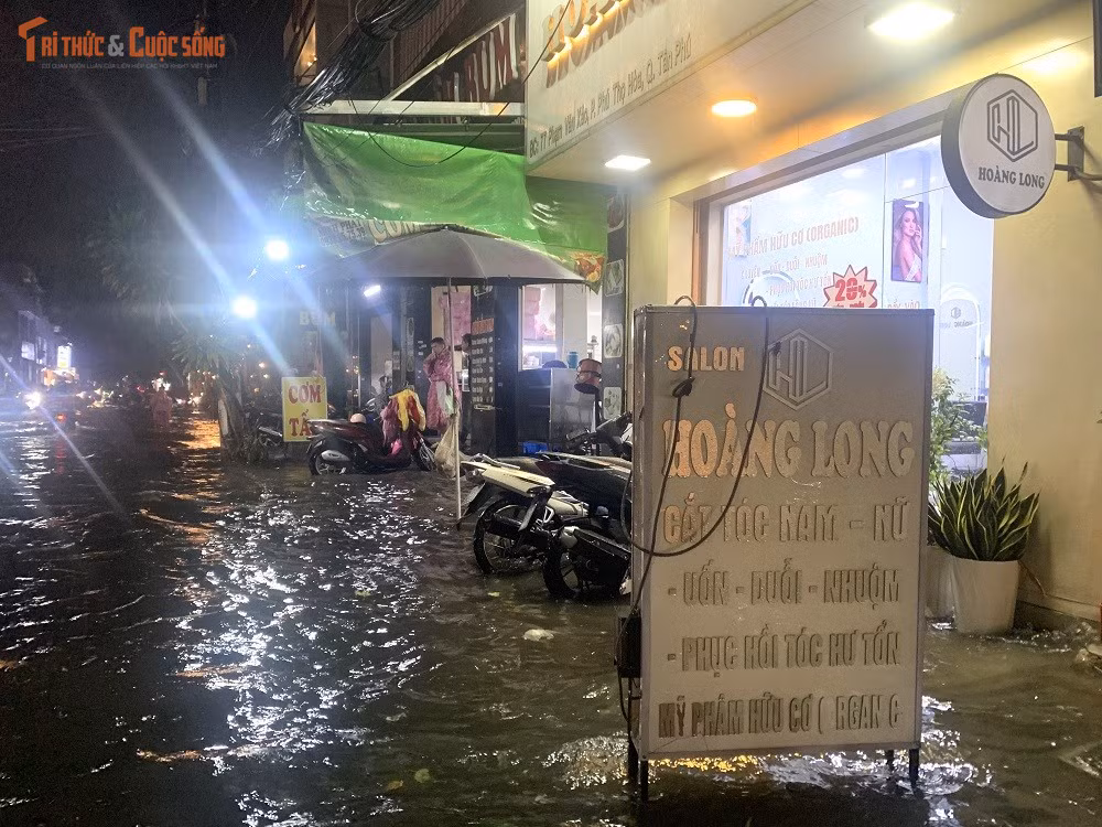 Mưa ngập đường khiến hoạt động kinh doanh, buôn bán của người dân hai bên đường bị đóng băng. Đến 20h30, nhiều khu vực vẫn còn bị ngập nước.