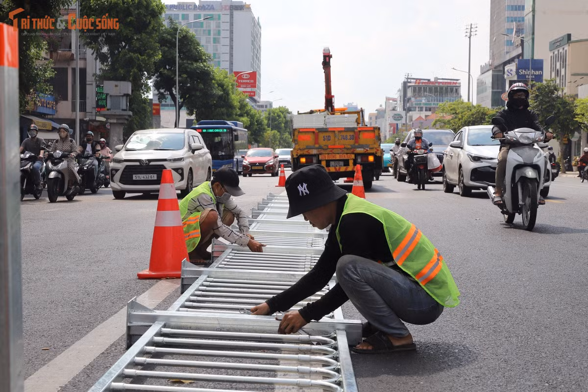 Trục đường vốn đã đông đúc nay càng thêm náo nhiệt bởi tiếng máy móc và nhịp độ làm việc cấp tập của đội ngũ thi công lắp dải phân cách.