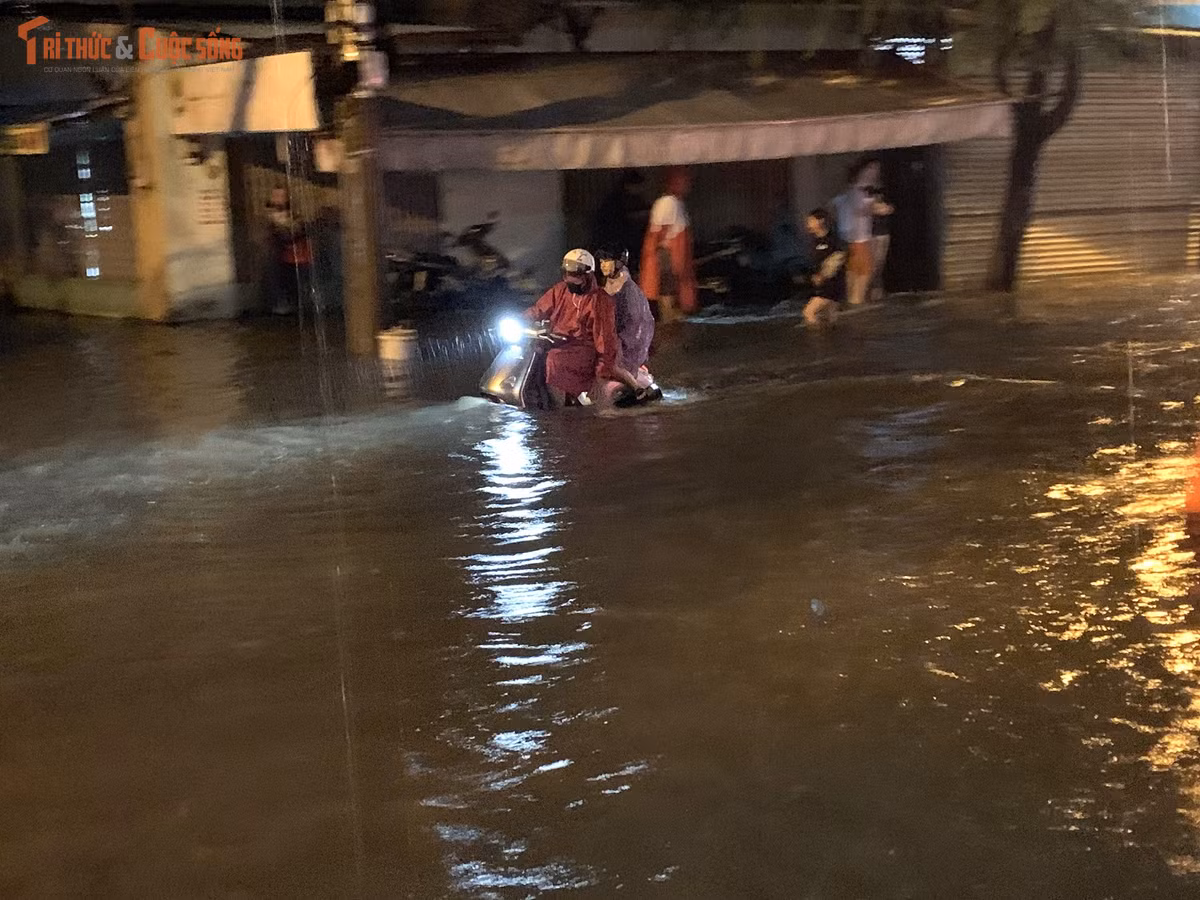 Người đàn ông gồng mình giữ thăng bằng xe máy để không bị ngã khi ô tô chạy qua tạo sóng nước trên đường. Đến 20h cùng ngày, nước trên đường Mã Lò vẫn còn ngập lênh láng.