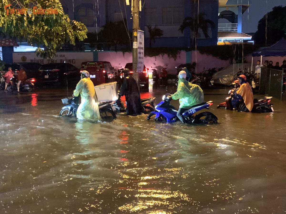 Người dân bì bõm dắt xe lội qua con đường mênh mông nước...