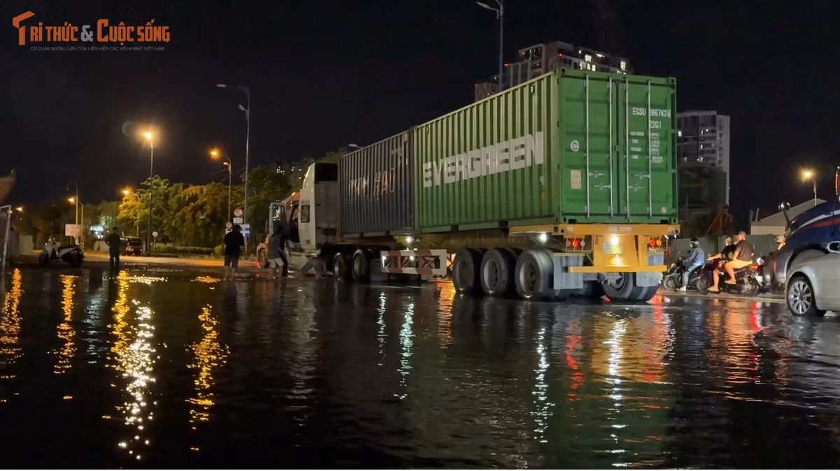Chiếc xe đầu kéo container bị "sập bẫy". Tài xế và một số công nhân công trình đã hỗ trợ nhau tìm cách "giải cứu" phương tiện ra khỏi hố sâu.
