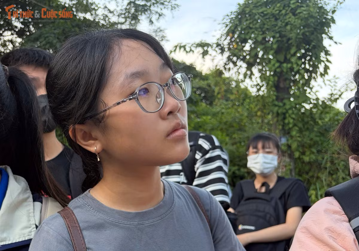 Sinh viên quan sát các xe buýt chạy đến trạm để chờ lên xe.