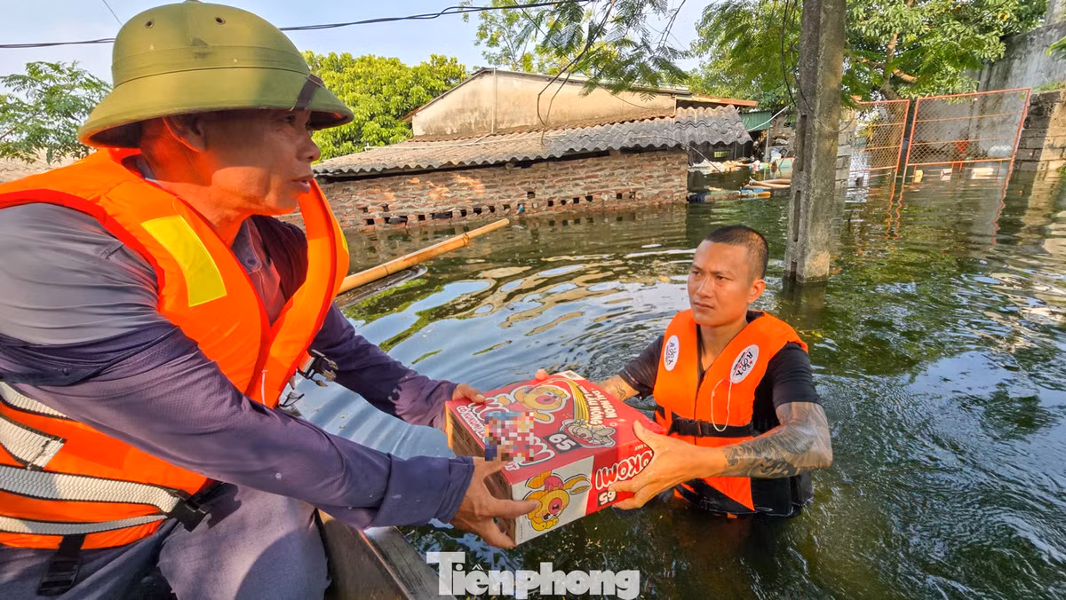 Nhu yếu phẩm được chuyển tới các hộ dân còn bị nước bao quanh sau nhiều ngày.