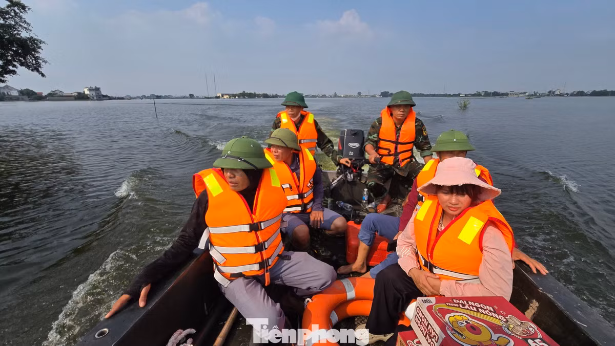 Đại diện thôn Mỹ Lương cùng chính quyền địa phương đi xuồng vào những khu vực còn ngập sâu để kiểm tra tình hình và hỗ trợ người dân.