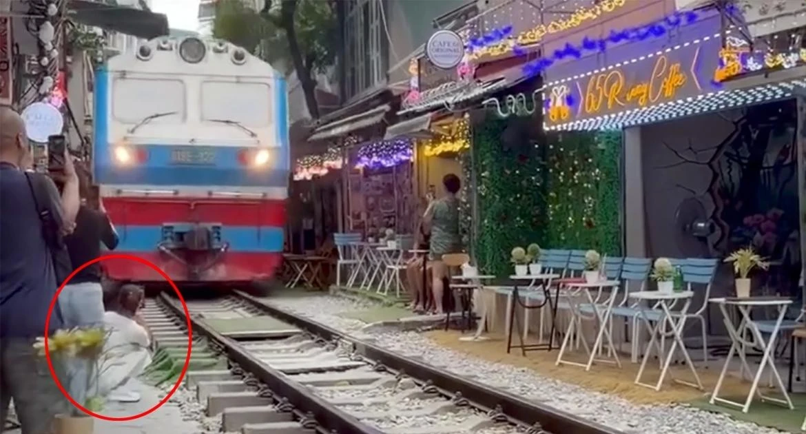 Ngồi sát đường ray, cô gái bị tàu hỏa hất văng điện thoại khỏi tay
