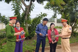 Cán bộ Công an xã Đắk Song phát tờ rơi tuyên truyền cho người dân.