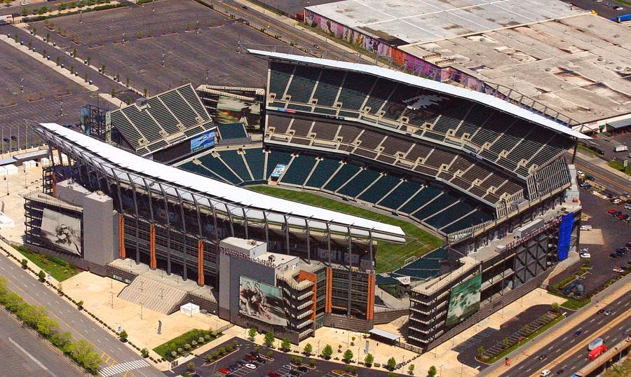Lincoln Financial Field là tác phẩm bắt tay giữa NBBJ và Agoos Lovera Architects. Lấy cảm hứng từ chính tên gọi của đội bóng chủ quản, hệ thống mái che phía Đông và phía Tây được tạo hình mềm mại như một đôi cánh đang dang rộng. Trải nghiệm thị giác này được hoàn thiện nhờ góc ban công "Eagle's Nest" ở phía Bắc sân, cùng biểu tượng đội bóng được định hình nổi bật bằng những hàng ghế xanh đậm tại khu vực khán đài trên cùng. (Ảnh: Fine Art America)