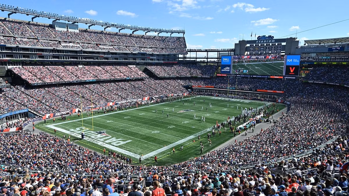 Cấu trúc khán đài của Gillette Stadium được thiết kế theo dạng bất đối xứng (Asymmetrical Bowl) và mở toang ở góc phía Bắc. Giải pháp kiến trúc này không chỉ giúp ánh sáng tự nhiên tràn ngập lòng sân, mà còn biến phần khuyết này thành một sân khấu vĩ đại để tôn vinh hai biểu tượng độc nhất: Cây cầu vòm và Ngọn hải đăng. (Ảnh: Gillette Stadium)