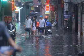 Người dân Hà Nội bì bõm lội nước sau cơn mưa lớn