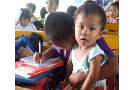 Không muốn bỏ học, cậu bé nghèo bế em tới lớp