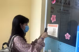 Người dân quét mã QR Code trước khi liên hệ làm việc tại Ủy ban Mặt trận Tổ quốc Việt Nam tỉnh Kiên Giang. Ảnh: Lê Sen/TTXVN