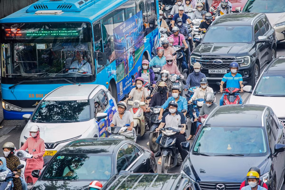 Nhiều phương tiện ô tô đi sát vỉa hè, làn ngoài cùng bên phải khiến hàng dài xe máy bị kẹt phía sau.