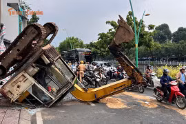 Xe múc đang thi công bất ngờ lật ngửa ra đường