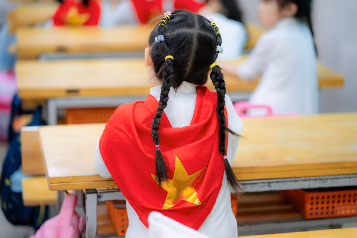 Những chiếc khăn quàng in hình cờ đỏ, sao vàng được các em nhỏ khoác lên mình đầy tự hào.