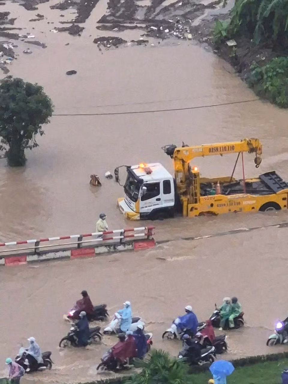 Khung cảnh giao thông giờ cao điểm vì thế trở nên hỗn loạn: dòng xe ken đặc, tiếng còi xe liên tục, người dân vội vã tìm cách thoát khỏi các điểm ngập. Những chiếc xe máy chết máy phải dựng tạm bên đường, trong khi ô tô nối đuôi nhau kéo dài.