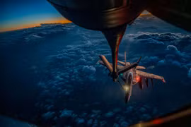 Một máy bay tiếp dầu KC-135 Stratotanker của Không quân Mỹ đang tiếp nhiên liệu trên không cho tiêm kích F/A-18F Super Hornet của Hải quân Mỹ trên bầu trời Trung Đông trong chiến dịch Epic Fury, minh họa cho hoạt động hỗ trợ tiếp dầu trên không phối hợp giữa các lực lượng. Hoạt động này giúp kéo dài thời gian hoạt động của tiêm kích, duy trì nhịp độ không kích và tăng thời gian hiện diện trên khu vực tác chiến cho các nhiệm vụ chiến đấu. (Nguồn ảnh: Bộ Quốc phòng Mỹ)