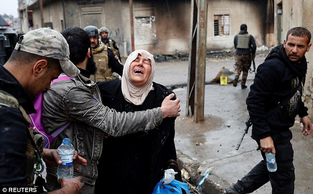 Người phụ nữ òa khóc sau khi trốn khỏi quận phía tây Mosul do IS chiếm giữ để sang khu mới được quân đội chính phủ giải phóng. Ảnh Daily Mail
