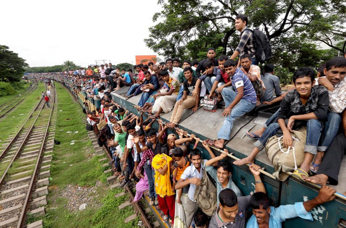 Bất chấp nguy hiểm luôn rình rập. những nam thanh niên Bangladesh đu mình bên hông cửa sổ hay ngồi hẳn trên nóc tàu đường sắt. Ảnh The Sun