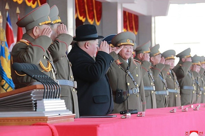 Ông Kim Jong-un và các tướng lĩnh cùng giơ tay chào lực lượng quân đội tham gia diễu hành. Ông Kim đội thêm mũ, do thời tiết khi đó ở Bình Nhưỡng rất lạnh (âm nhiều độ C).